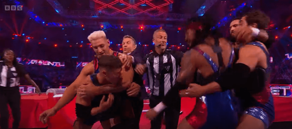 Wrestlers celebrating in a ring.