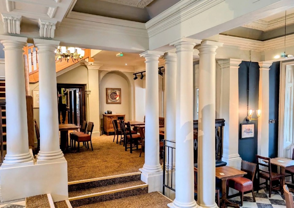 Interior view of a restaurant with columns and tables.