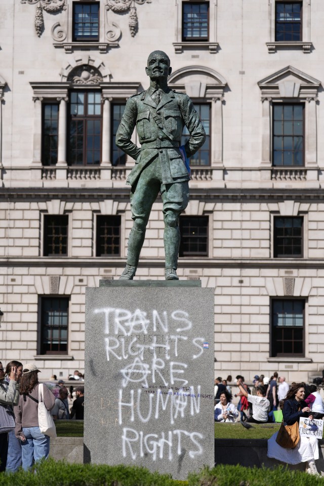 Graffiti reading "Trans Rights Are Human Rights" on a statue in Parliament Square.