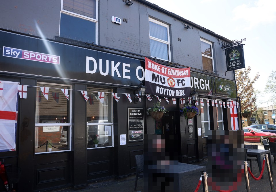 The Duke of Edinburgh pub in Royton, Oldham, decorated with England flags and a Manchester United banner.