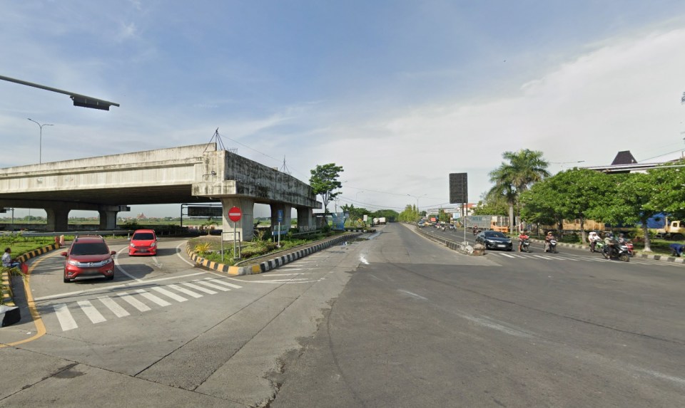 Road intersection with an unfinished bridge and cars.
