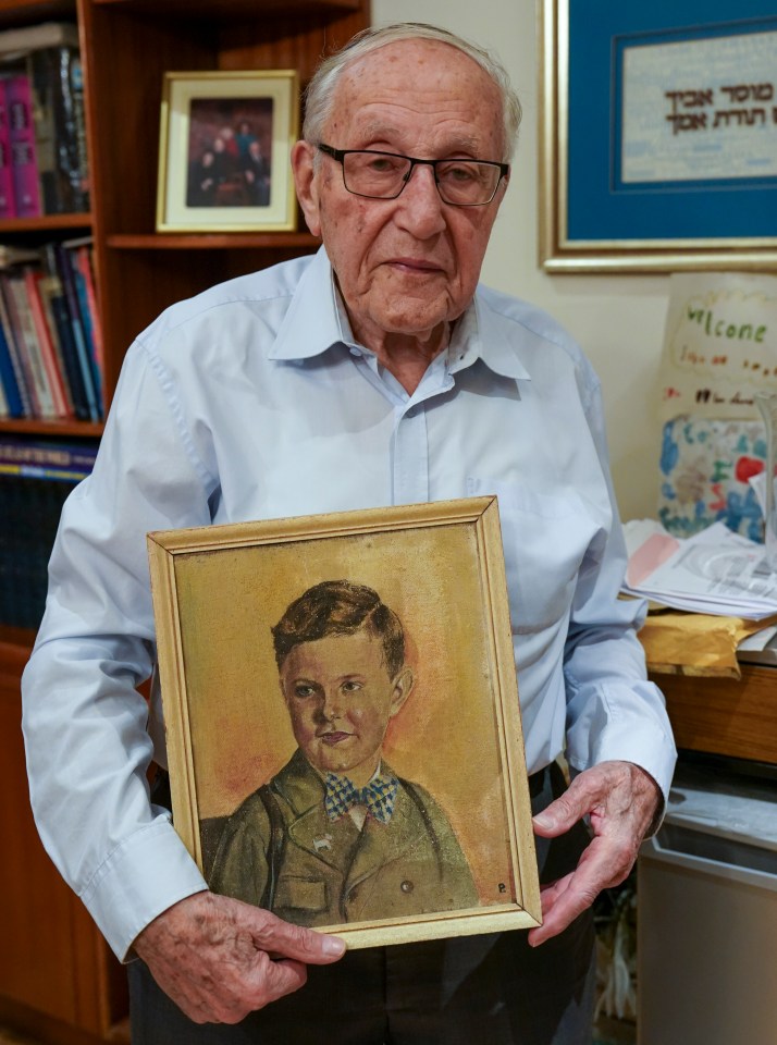 Holocaust survivor holding a painting of his brother.