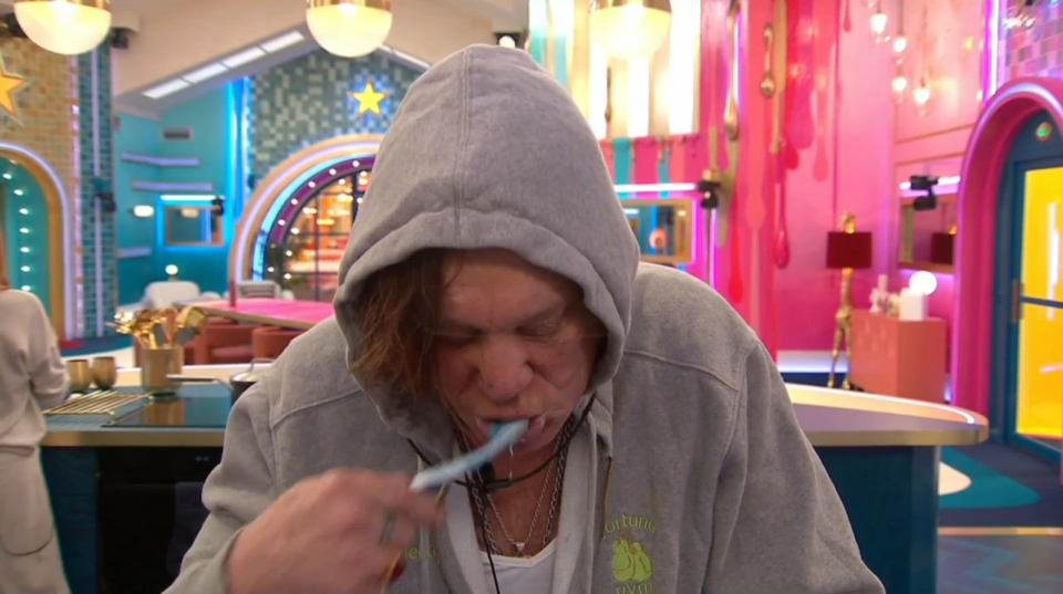 Man brushing his teeth in a brightly colored room.
