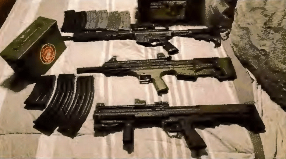Three firearms and several magazines on a beige surface.