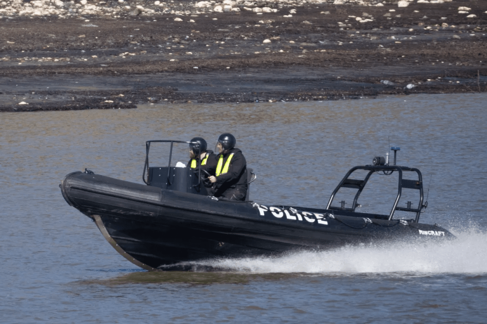 Police officers in a rigid-hulled inflatable boat.