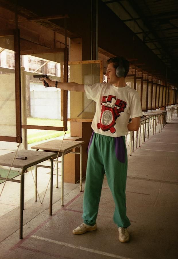 Person shooting a handgun at an indoor shooting range.
