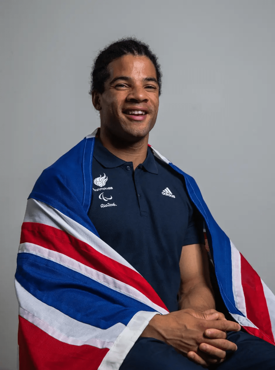 Smiling man draped in a flag.