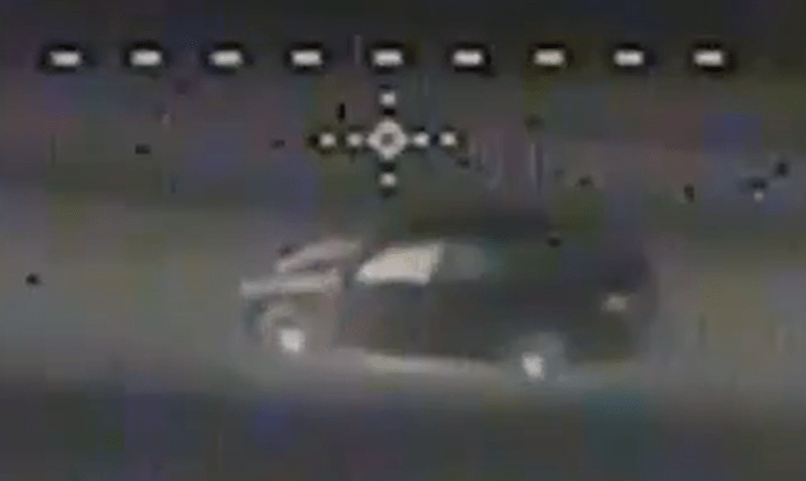 Blurry image of a dark-colored SUV.