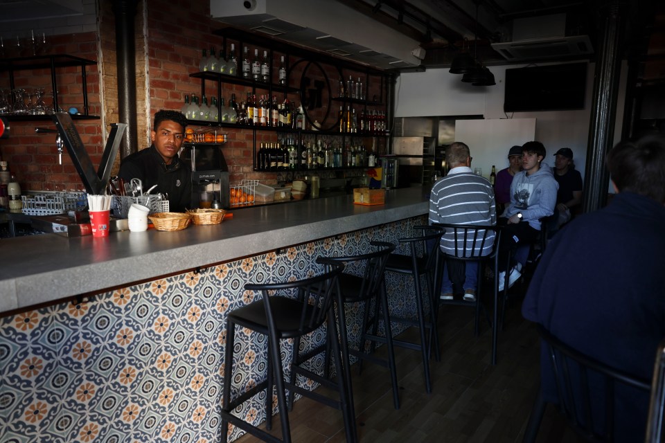 Bartender at a bar with customers.