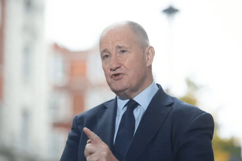 Man in suit speaking and gesturing.