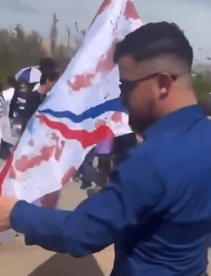 Man holding a stained flag.