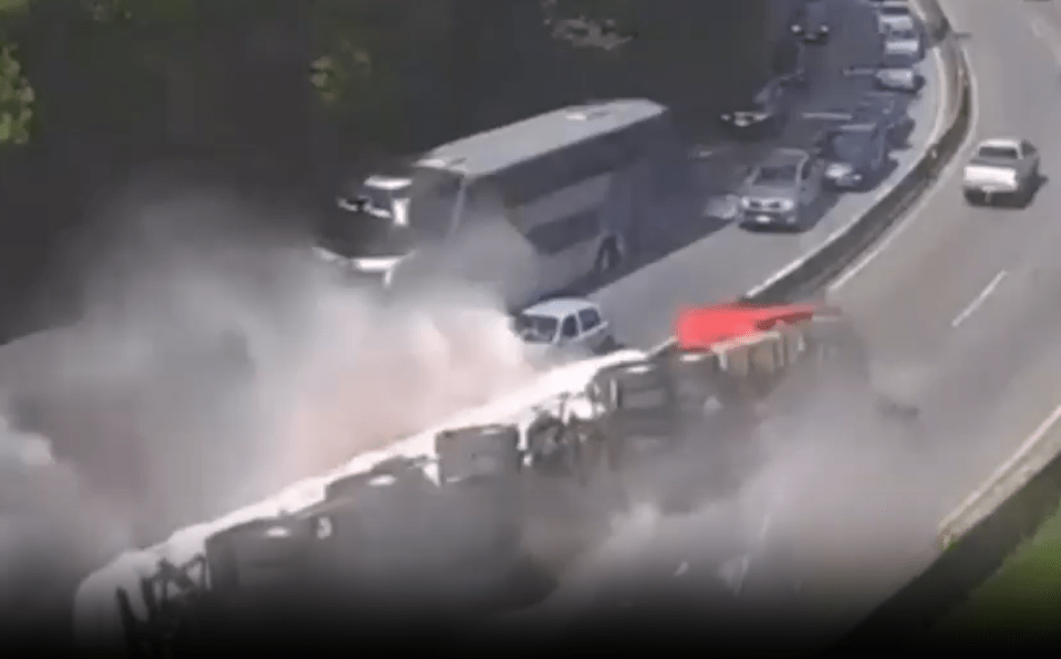 Multi-vehicle accident on highway with large cloud of dust or smoke.
