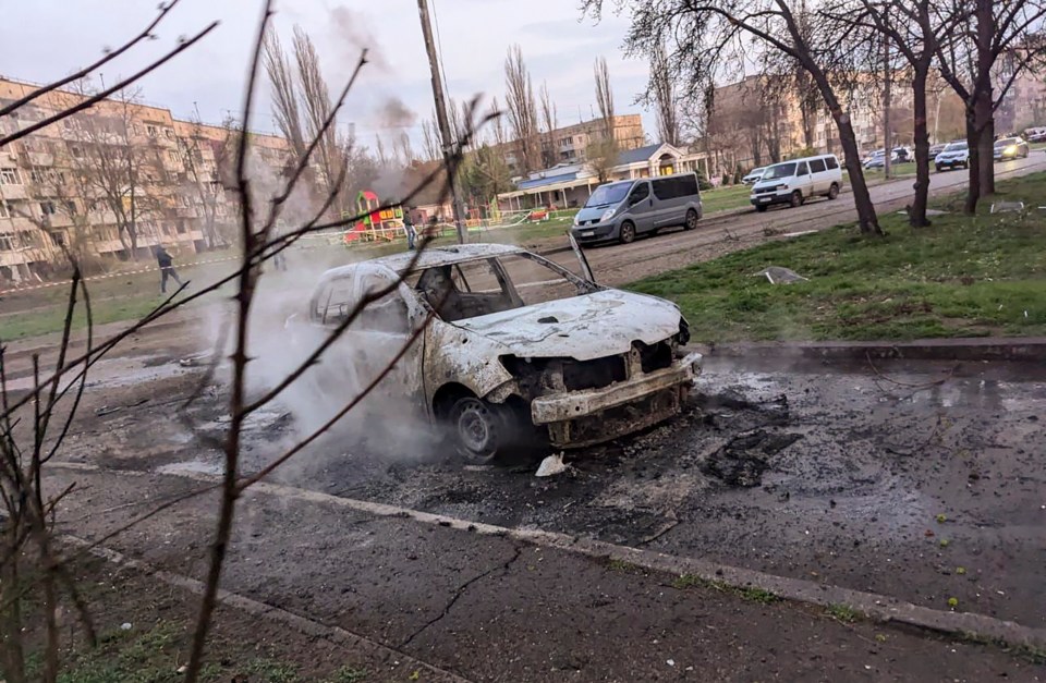 Burned-out car emitting smoke.
