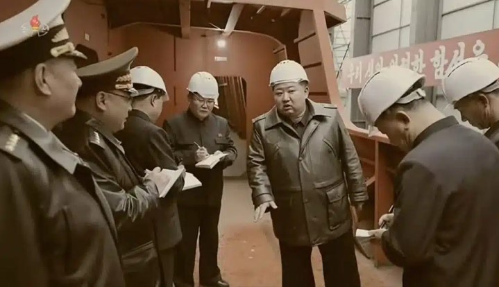 Kim Jong-un and several officials inspecting a ship's construction.