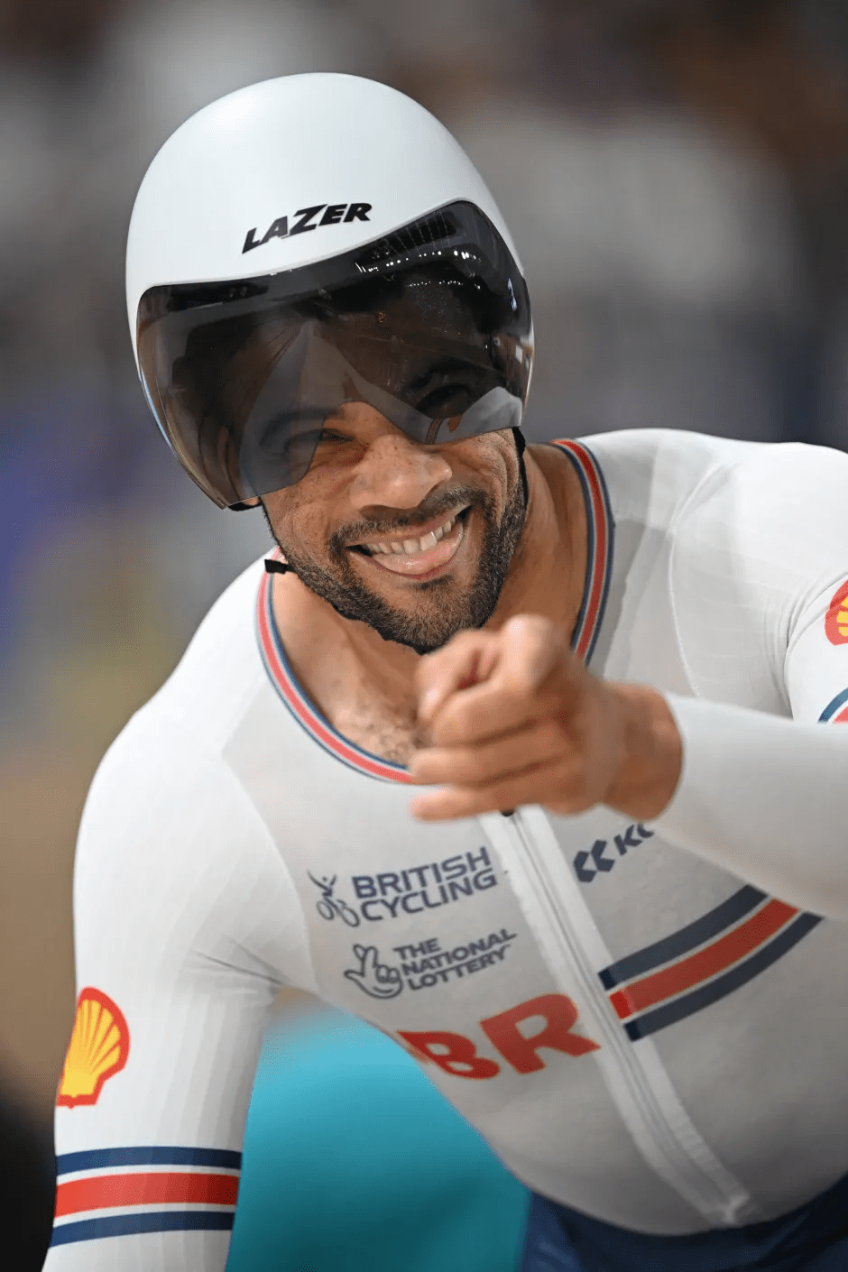 Smiling cyclist pointing at the camera.