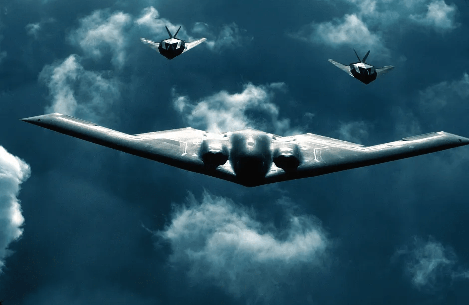 B-2 Spirit bomber with two fighter jets flying above a cloudy sky.