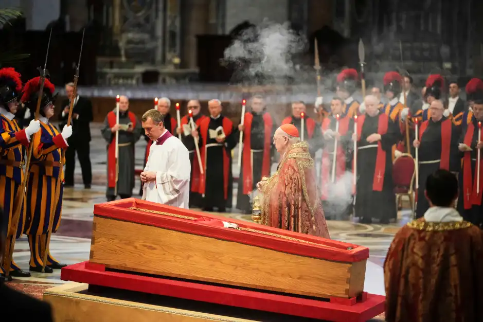 A cardinal and clergy members at a funeral service.