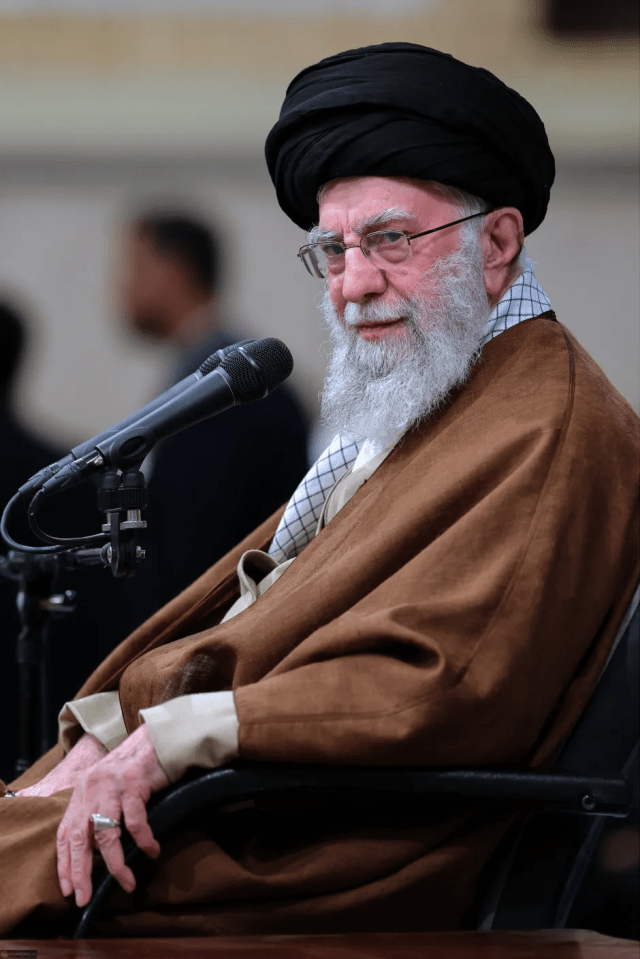 Portrait of Ali Khamenei speaking into a microphone.