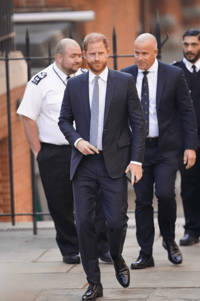 Prince Harry walking with security.