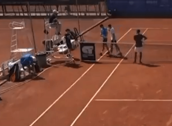 Tennis court crew repairing a net.