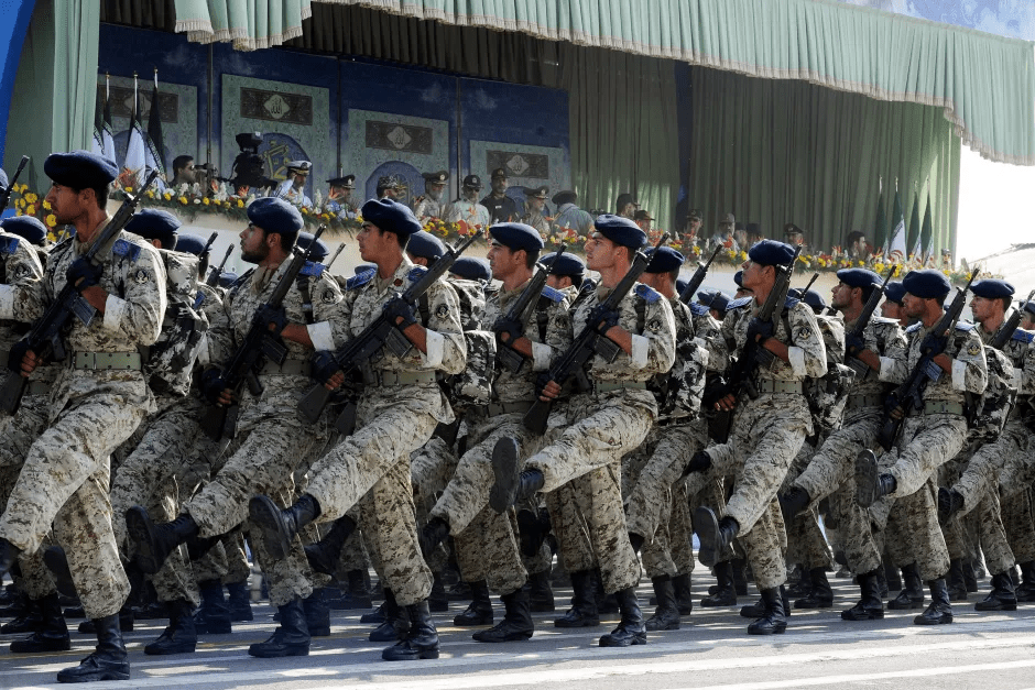 Soldiers in camouflage uniforms marching in formation, carrying rifles.