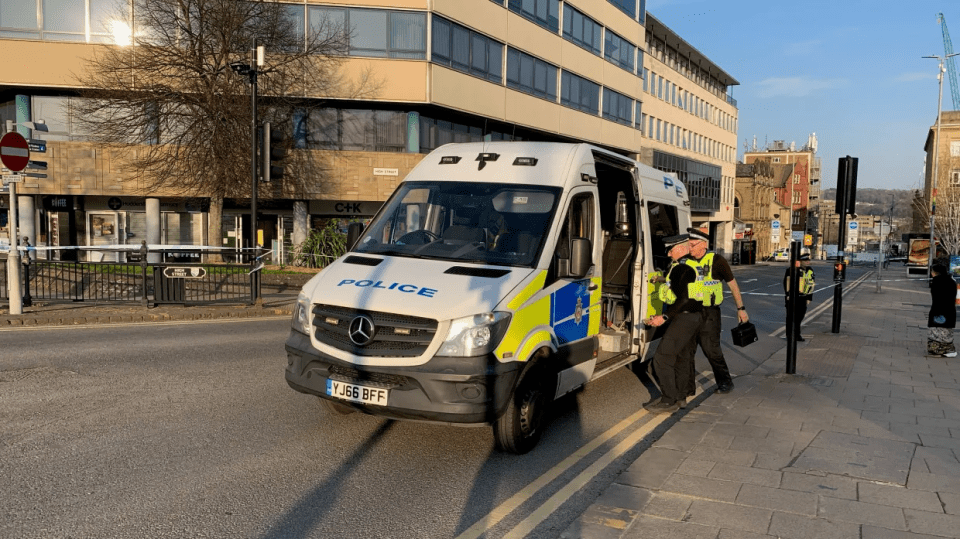 Police van and officers at a crime scene.