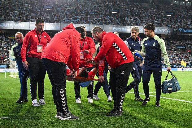 Injured soccer player being carried off the field on a stretcher.