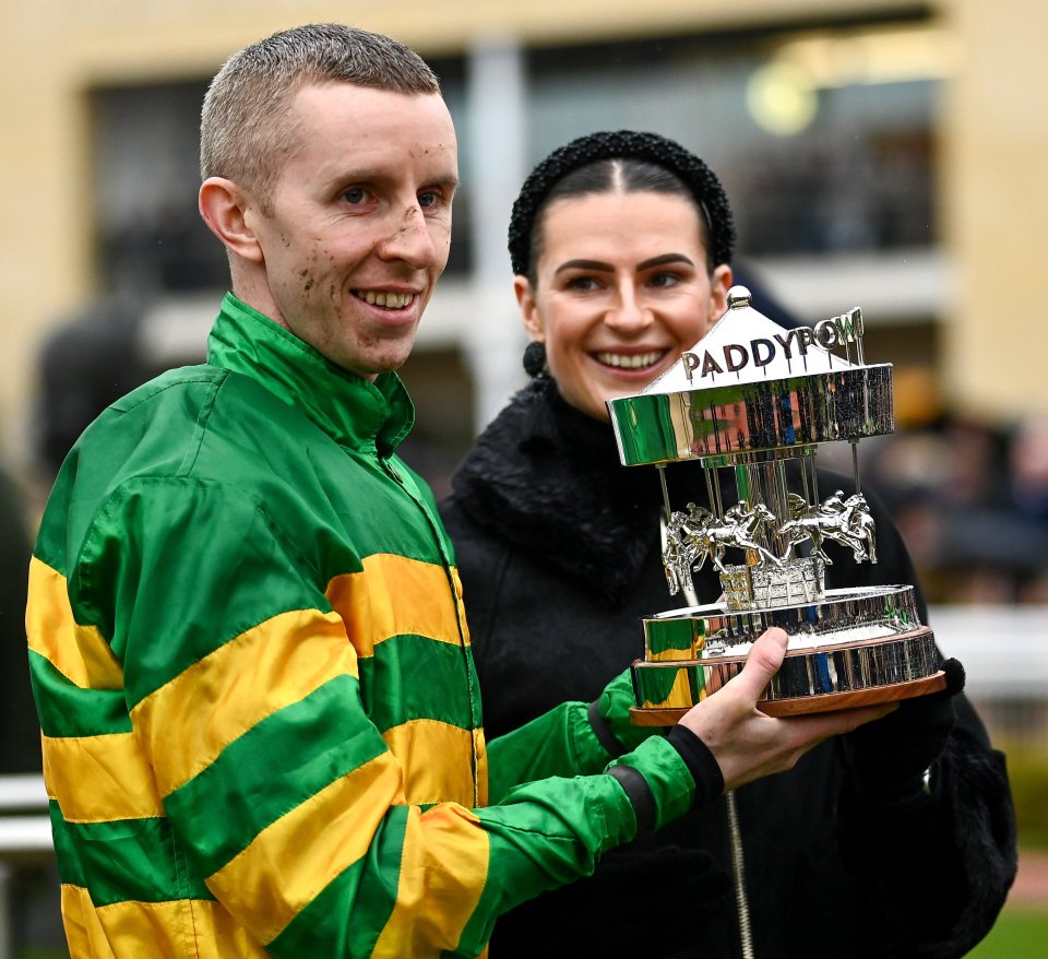 Jockey Mark Walsh and his partner holding a trophy.