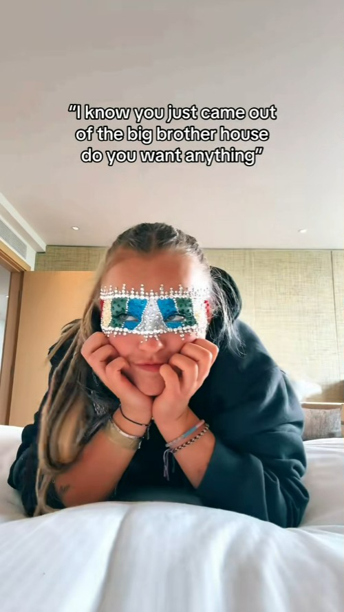 JoJo Siwa wearing a mask and resting her chin on her hands.