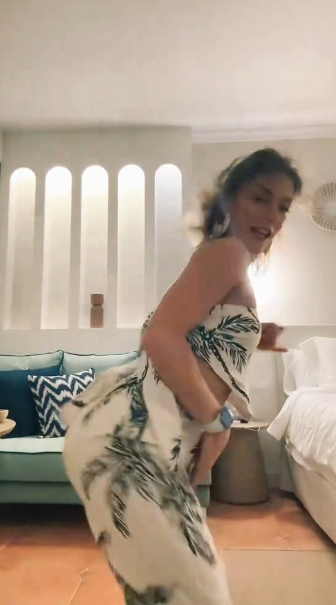 Woman in palm tree print pants dancing.