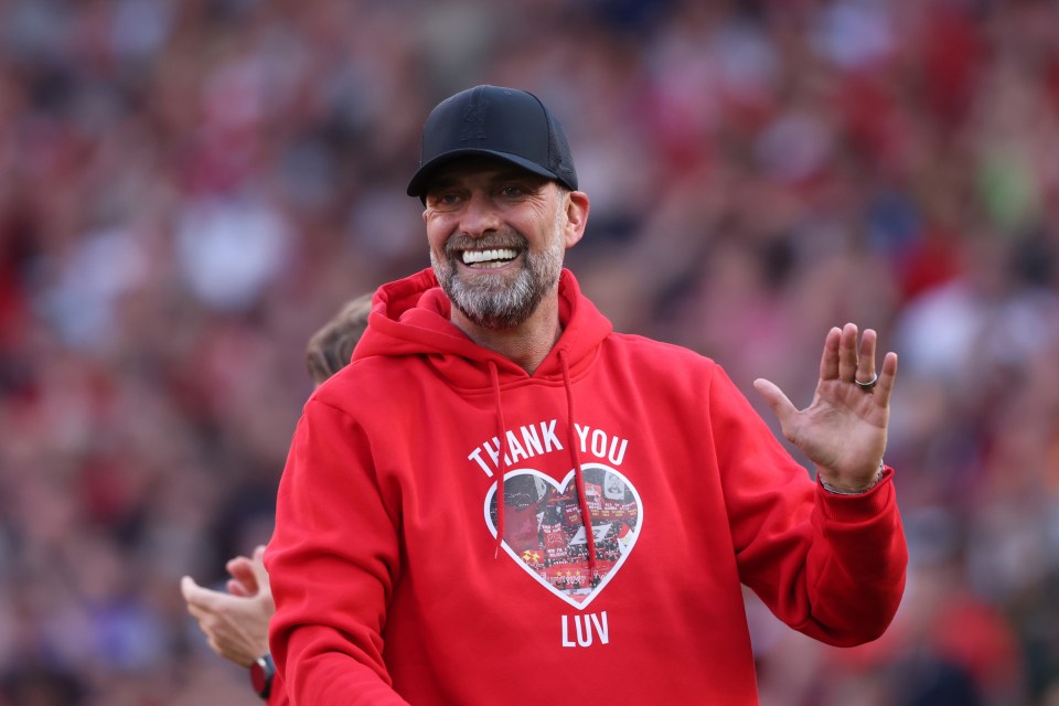 Jurgen Klopp, Liverpool manager, wearing a "Thank You Luv" hoodie, waves to fans.