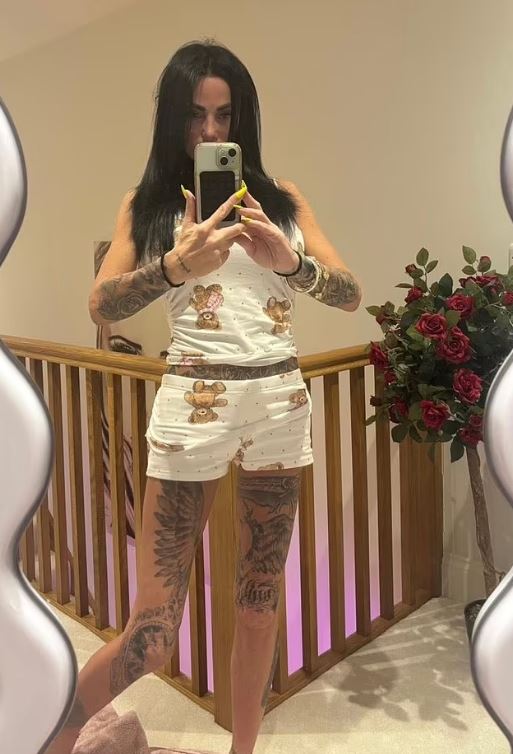 Woman taking a selfie in a teddy bear-print pajama set.