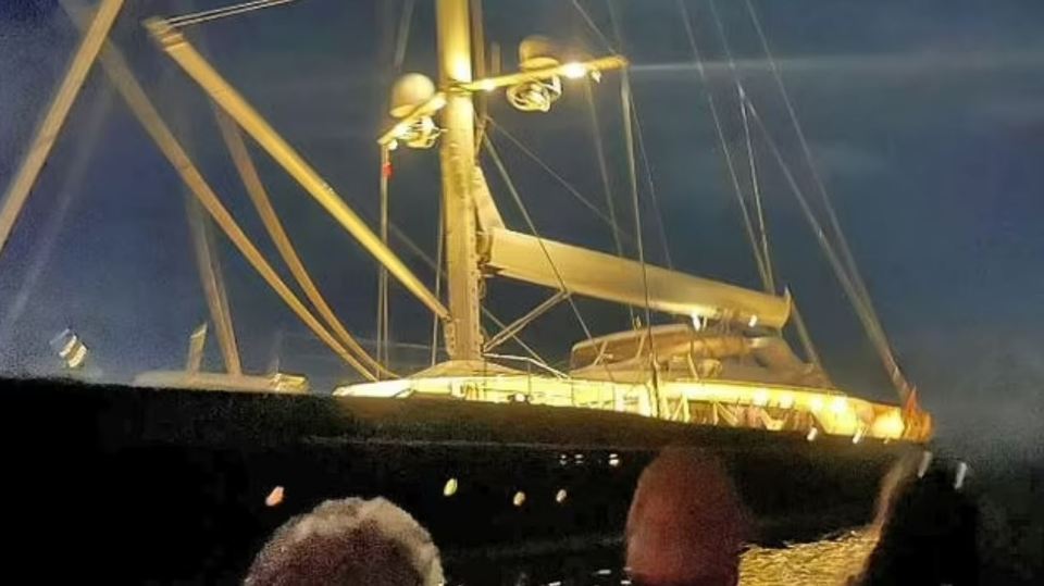 Nighttime photo of a yacht's mast and deck.