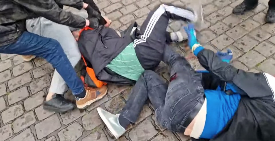 People subduing a person on the ground.