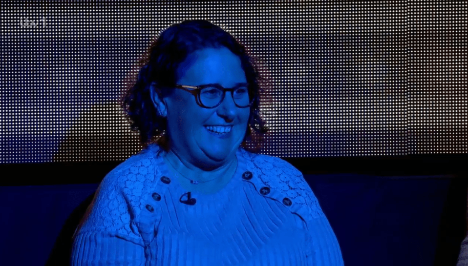 Woman smiling in front of a screen.