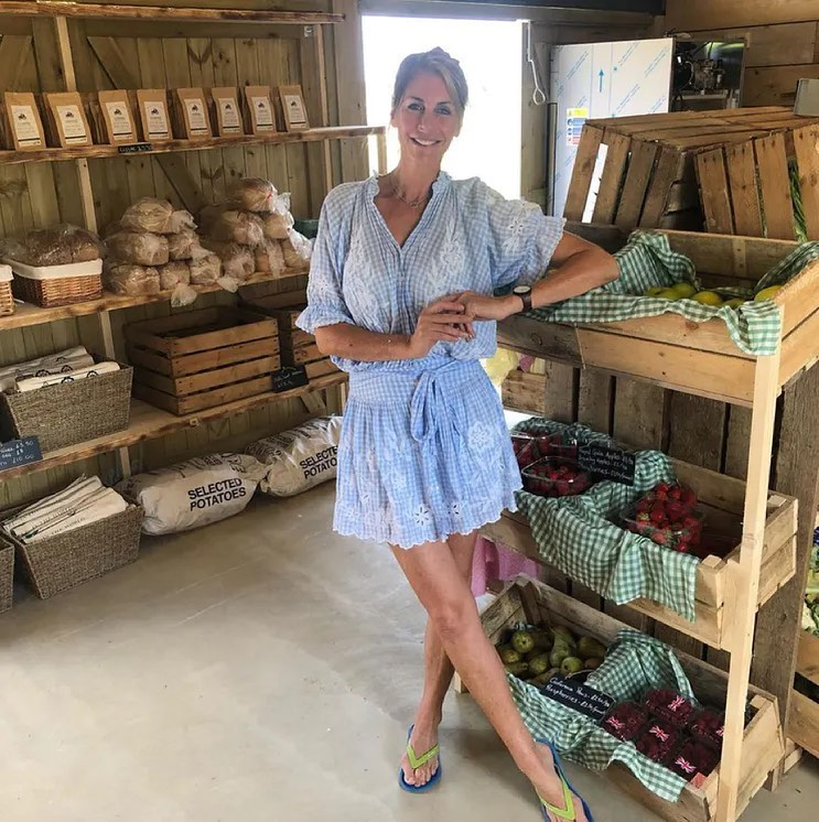 Woman in blue dress standing in a farm shop.