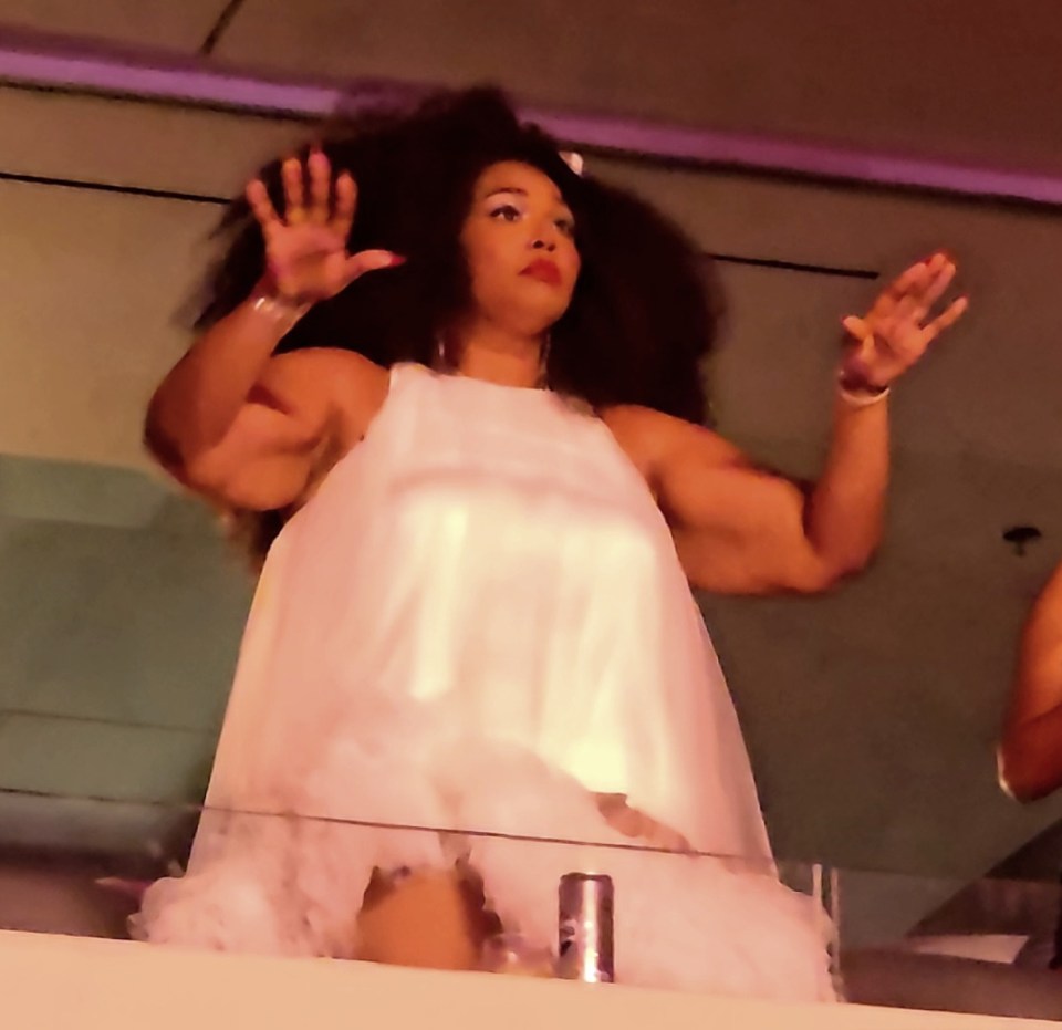 Lizzo in a white dress at a concert.
