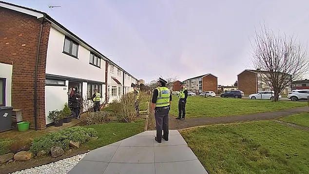 Police officers outside a house.
