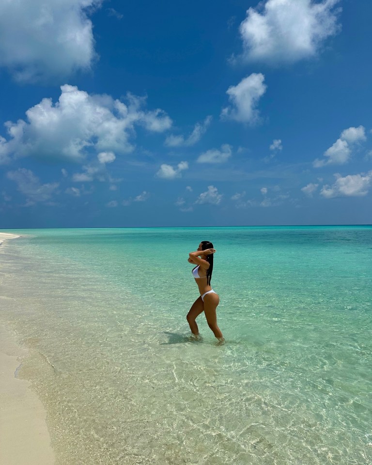 Kady McDermott in a white bikini on a beach.