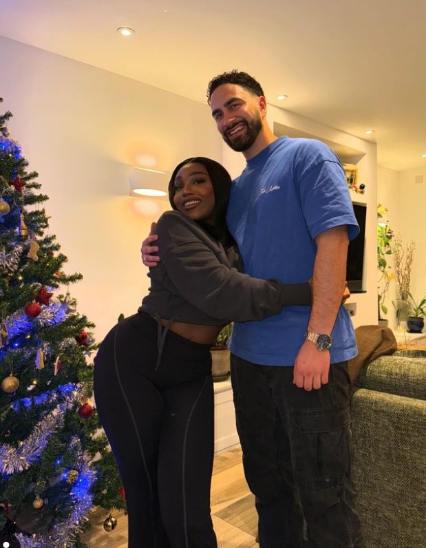 Whitney Adebayo and Lochan hugging near a Christmas tree.