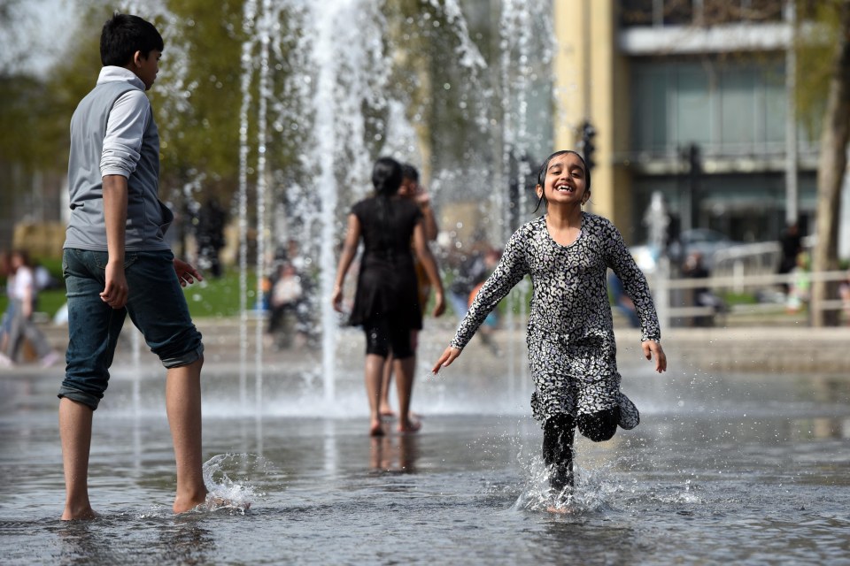 Girl splashing in a fountain.