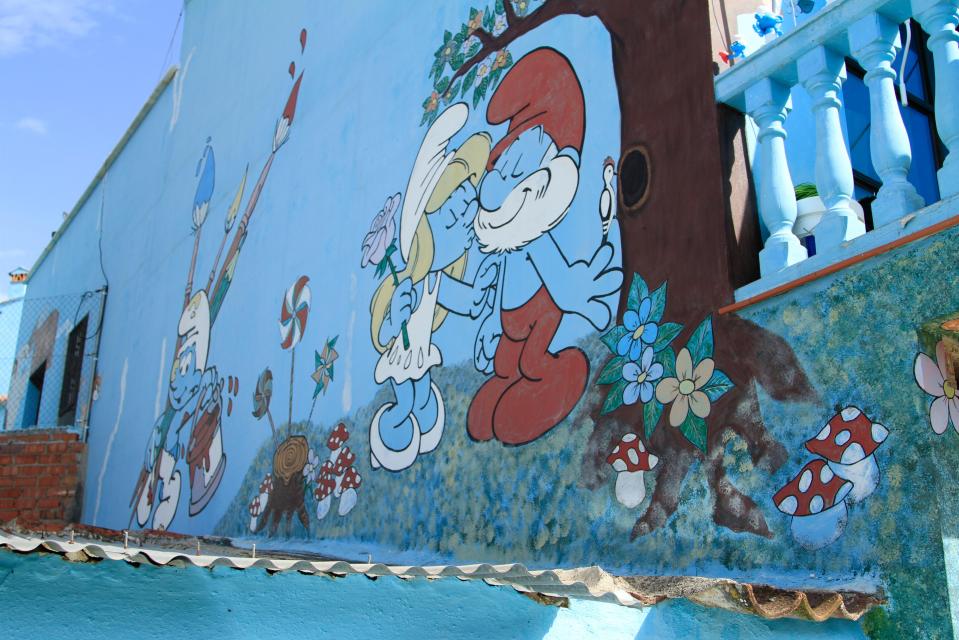 Mural of Smurfs on a blue building.
