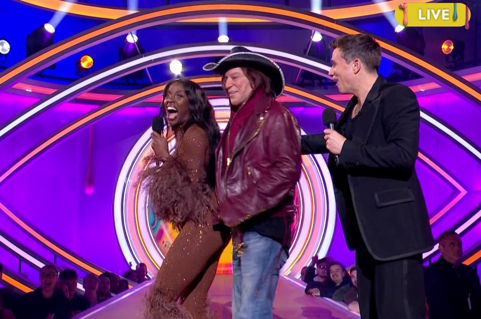 Mickey Rourke, AJ Odudu, and a presenter on a game show.