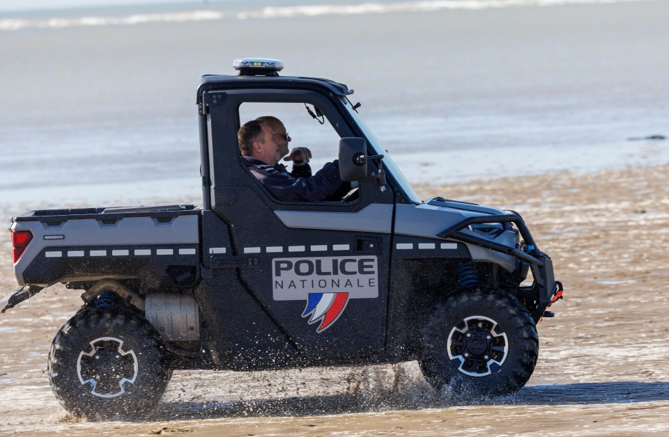 Police ATV driving on a beach.