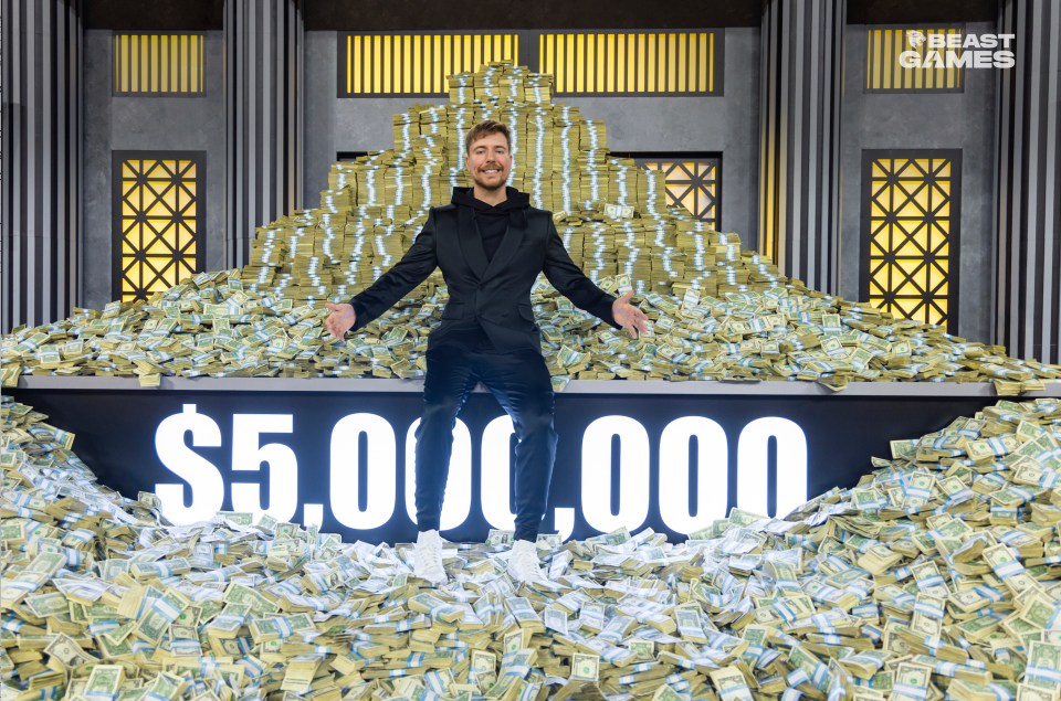 MrBeast sitting on a large pile of money on the set of Beast Games.