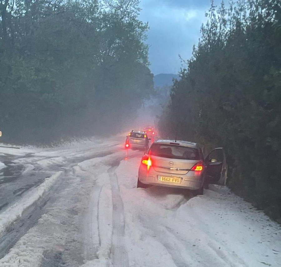 Cars stopped on a hail-covered road.