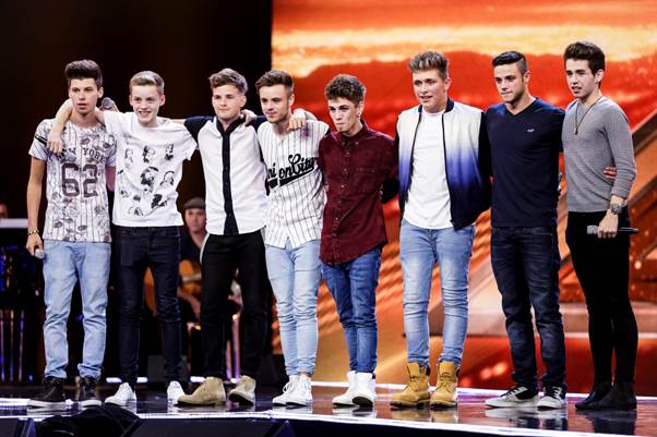 Eight boy band contestants posing together.
