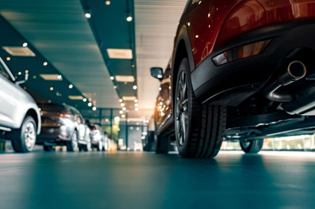 An image collage containing 1 images, Image 1 shows Rear view of parked cars in a car dealership showroom