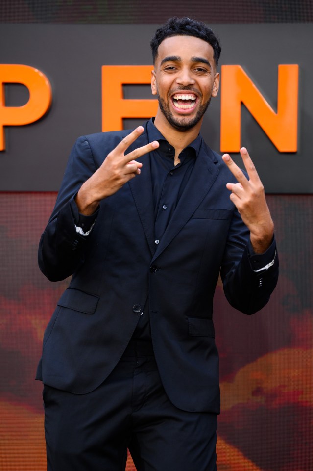 Niko Omilana at the Oppenheimer UK premiere, giving a peace sign.