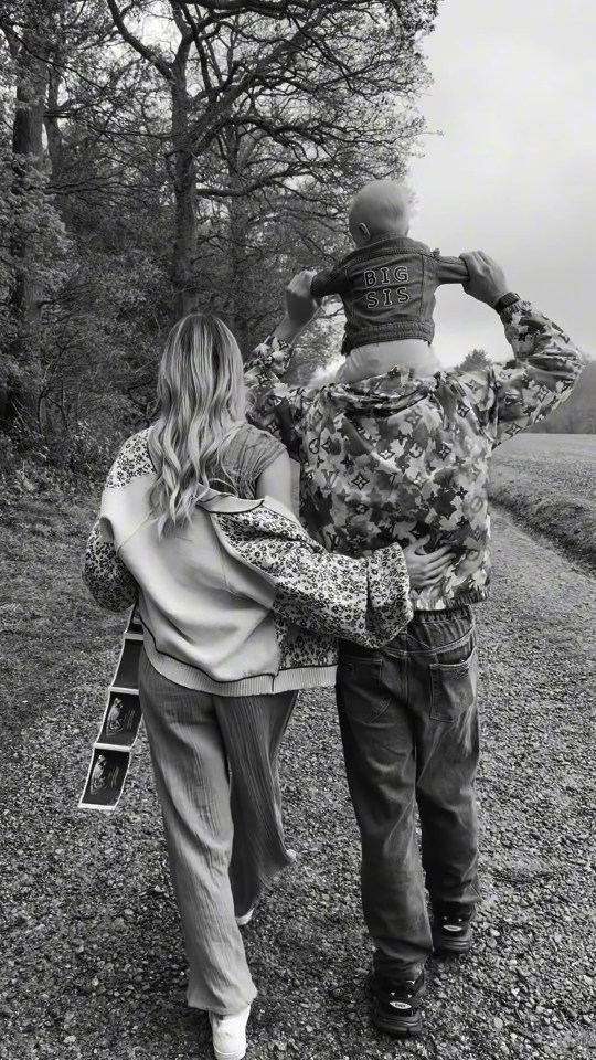 Black and white photo of a family announcing a pregnancy.
